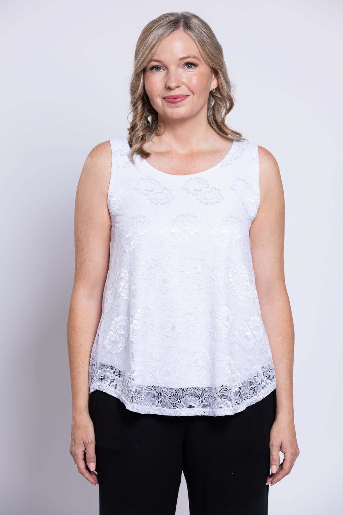Front view of woman in white sleeveless lace overlay tank top