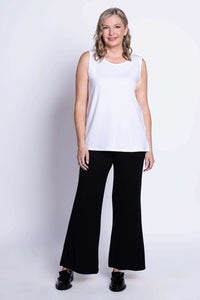 Front view of woman modeling white sleeveless tank top with black pants