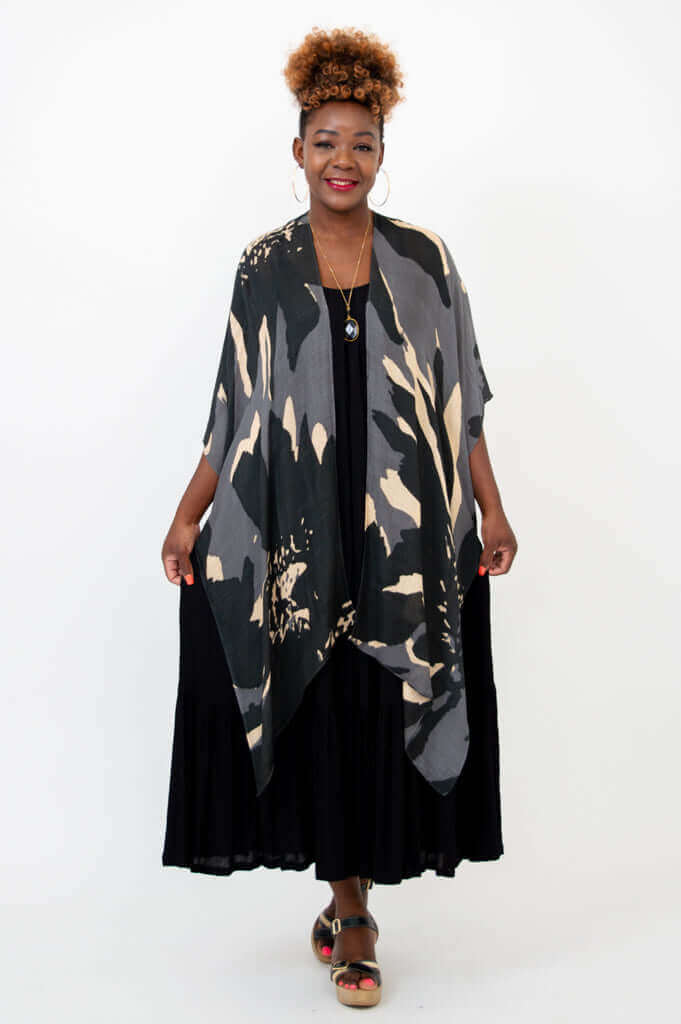 Front view of woman wearing Darcy kimono wrap in black and beige with black dress
