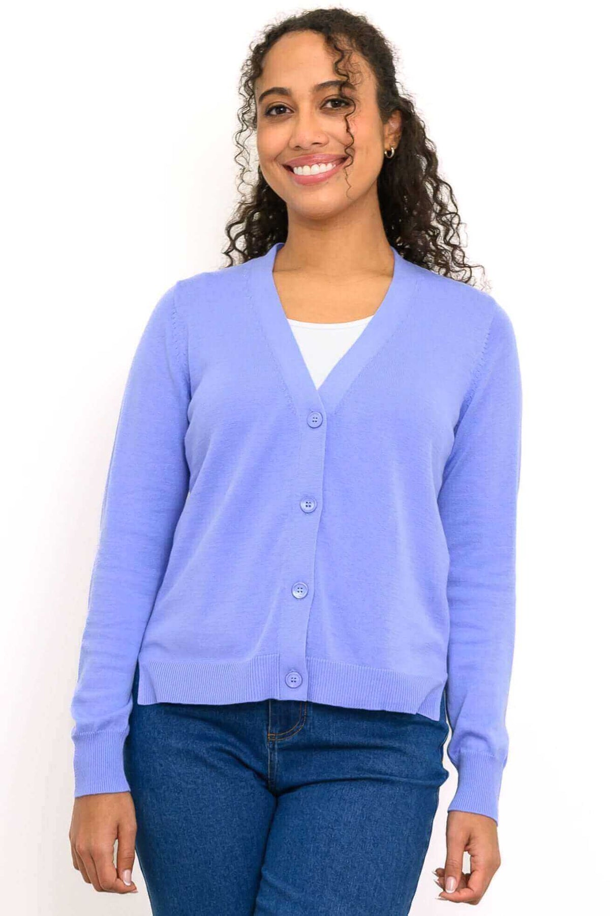 Front view of woman wearing a light purple V-neck button-up cardigan and blue jeans