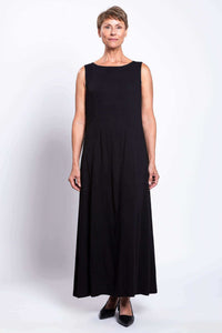 Front view of woman wearing a sleeveless black shift maxi dress with boat neck