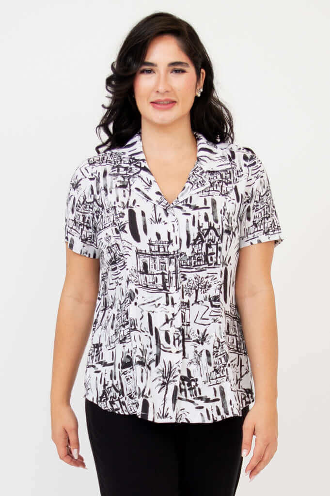Front view of woman wearing black and white patterned short sleeve shirt
