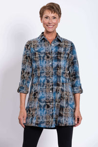Front view of woman wearing a blue and brown plaid flannel tunic with tabbed cuffs