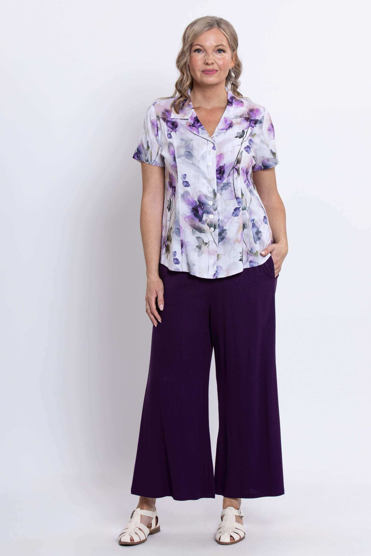 Front view of woman wearing floral bamboo-linen blouse with purple wide-leg pants