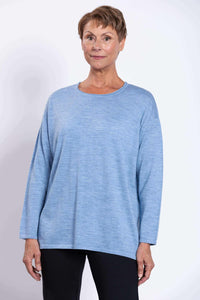 Front view of woman wearing light blue Merino wool sweater with black pants