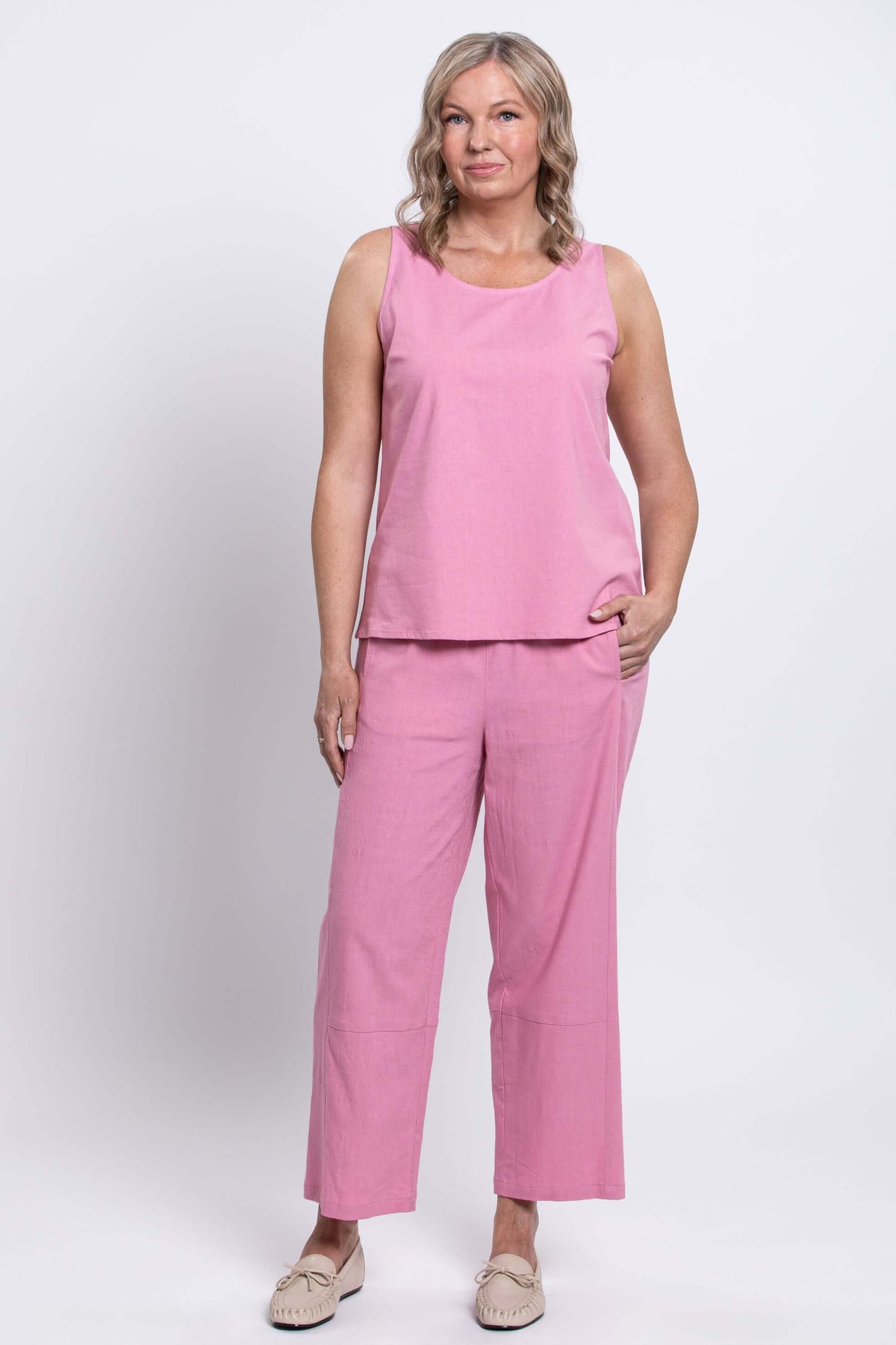 Woman wearing pink sleeveless top and matching wide-leg cropped pants, front view