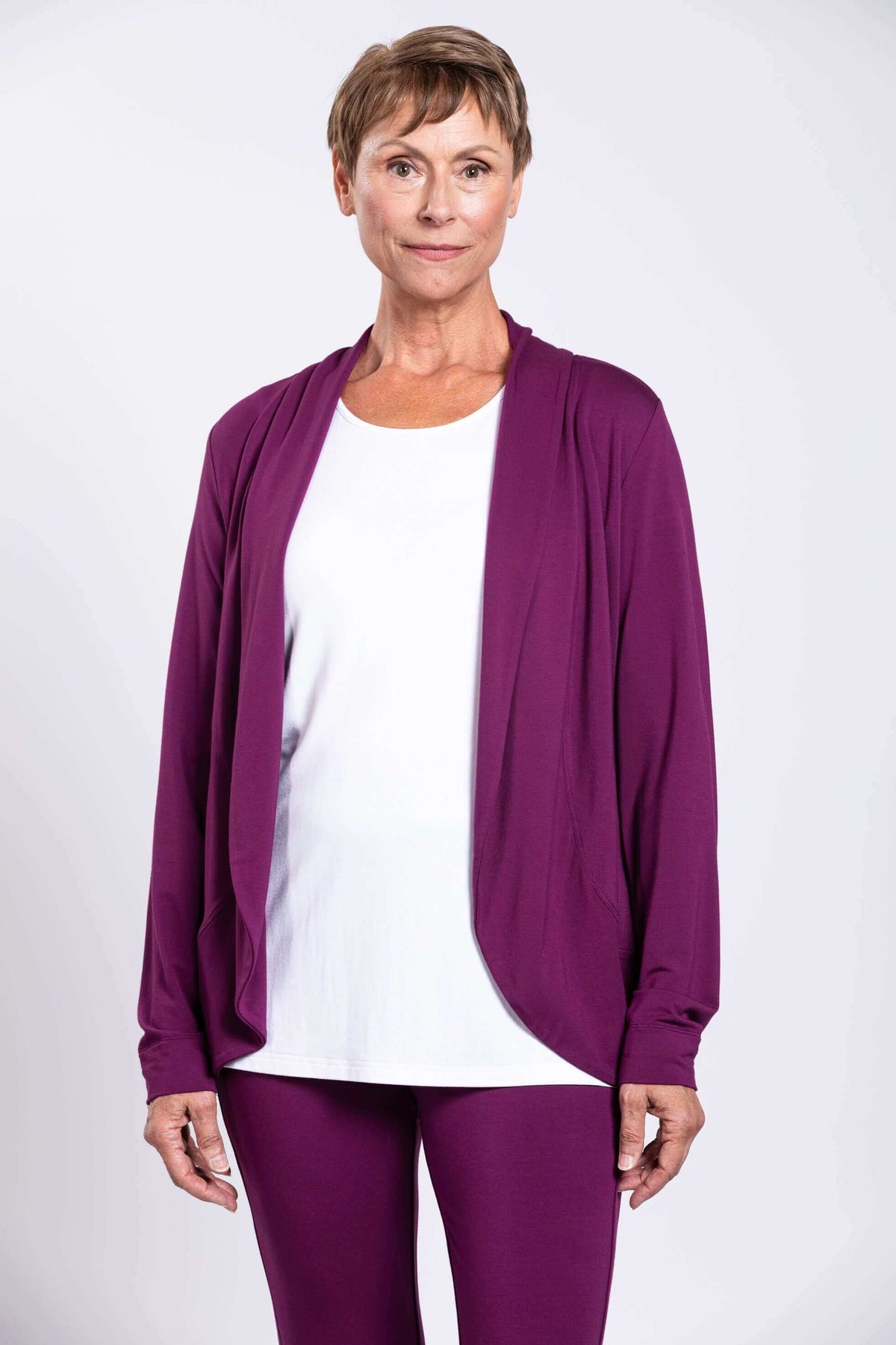 Front view of woman wearing plum purple French Terry jacket and white top
