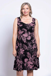 Front view of woman wearing sleeveless black dress with pink floral print