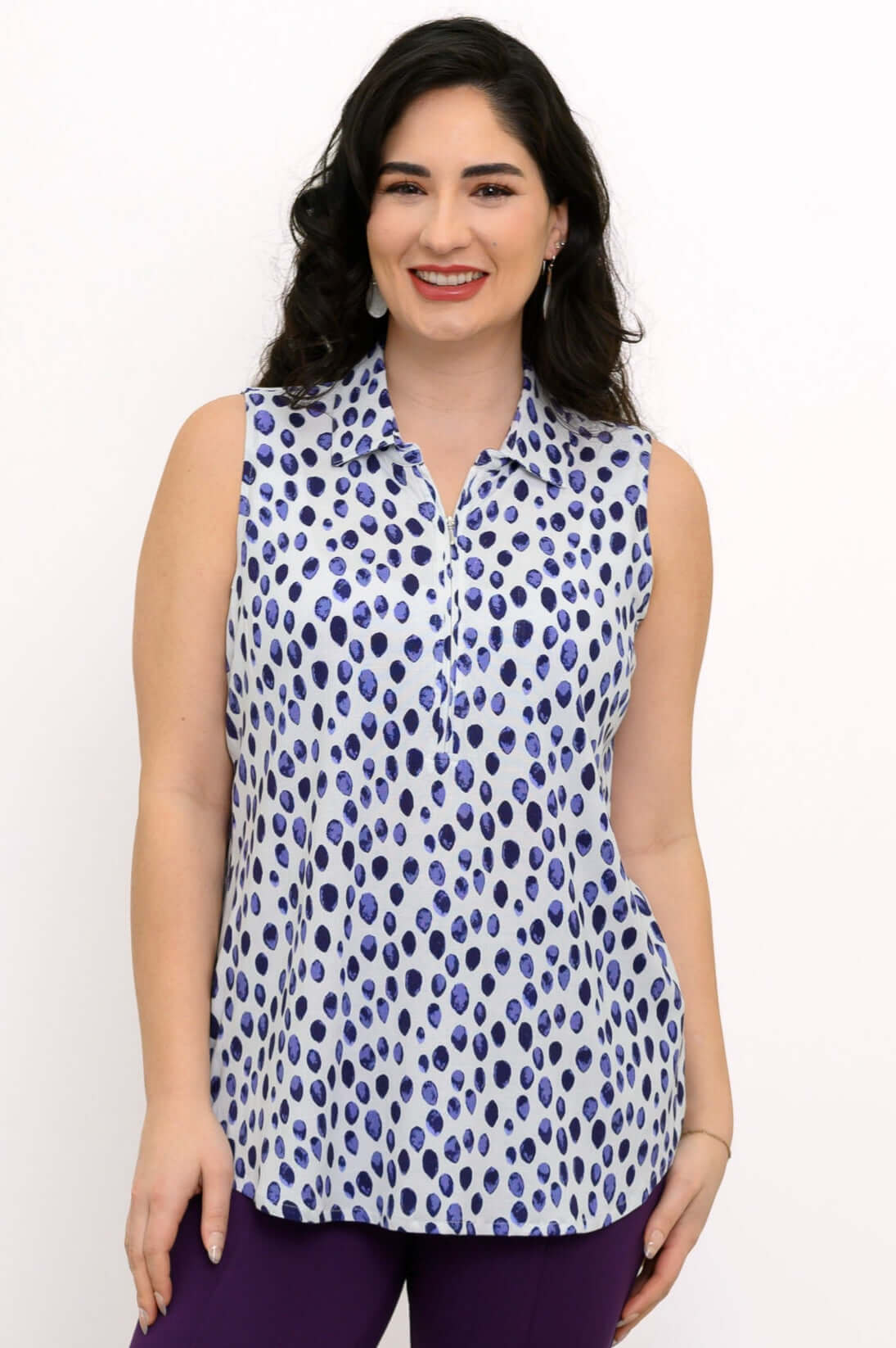 Front view of woman wearing sleeveless blue dot print tank top with collar