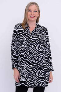 Front view of woman wearing a black and white zebra stripe tunic shirt