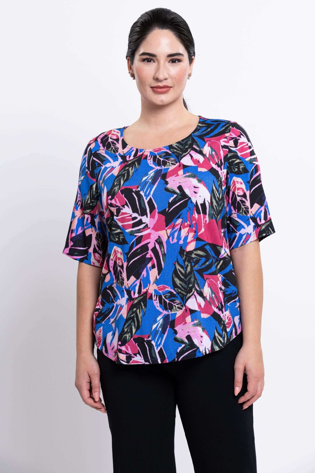 Front view of model wearing blouse with vibrant leaf print and elbow sleeves