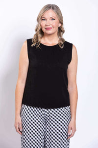 Front view of woman in black sleeveless tank top wth pleated round-neck detail and checkered pants