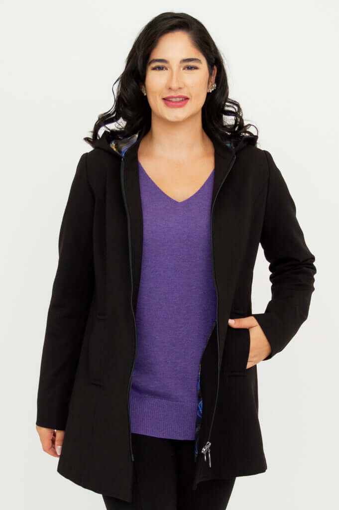 Front view of model wearing The Highlands Coat partially unzipped with hand in pocket