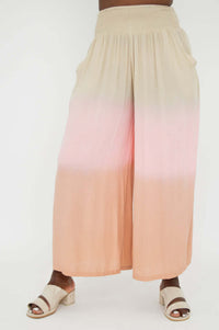 Front view with slight angle of ombre wide leg pants in peach and beige