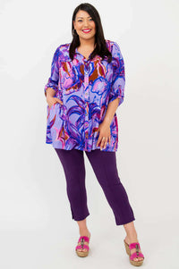 Full-length view of a model in a purple floral print tunic and purple capri pants