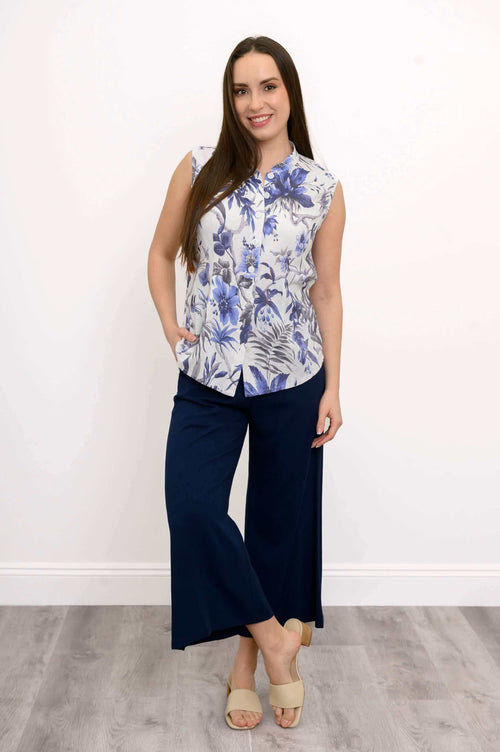 Full-body view of woman in blue floral tank and navy wide-leg pants