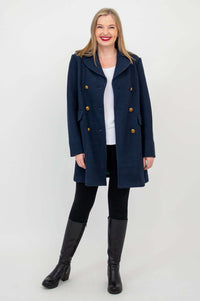 Full-body view of woman modeling navy pea coat with notched collar and gold buttons