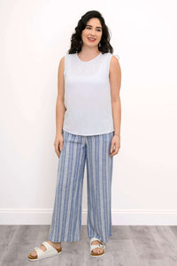 Full-body view of woman in white tank top and blue striped pants