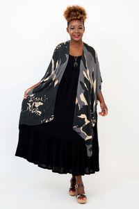 Model in relaxed pose wearing Darcy kimono wrap with abstract print