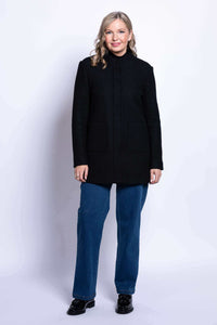 Full-length front view of woman in black boiled wool coat and blue jeans