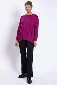 Full-length front view of a model in a berry Merino wool sweater and black pants