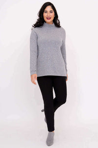 Full front view of model in grey mock neck sweater and black pants