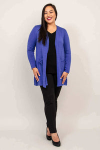 Full-length image of a woman in a royal blue open cardigan, black pants, and heels