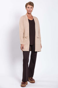 Full-length view of a model in a beige cardigan layered over a brown outfit and brown shoes