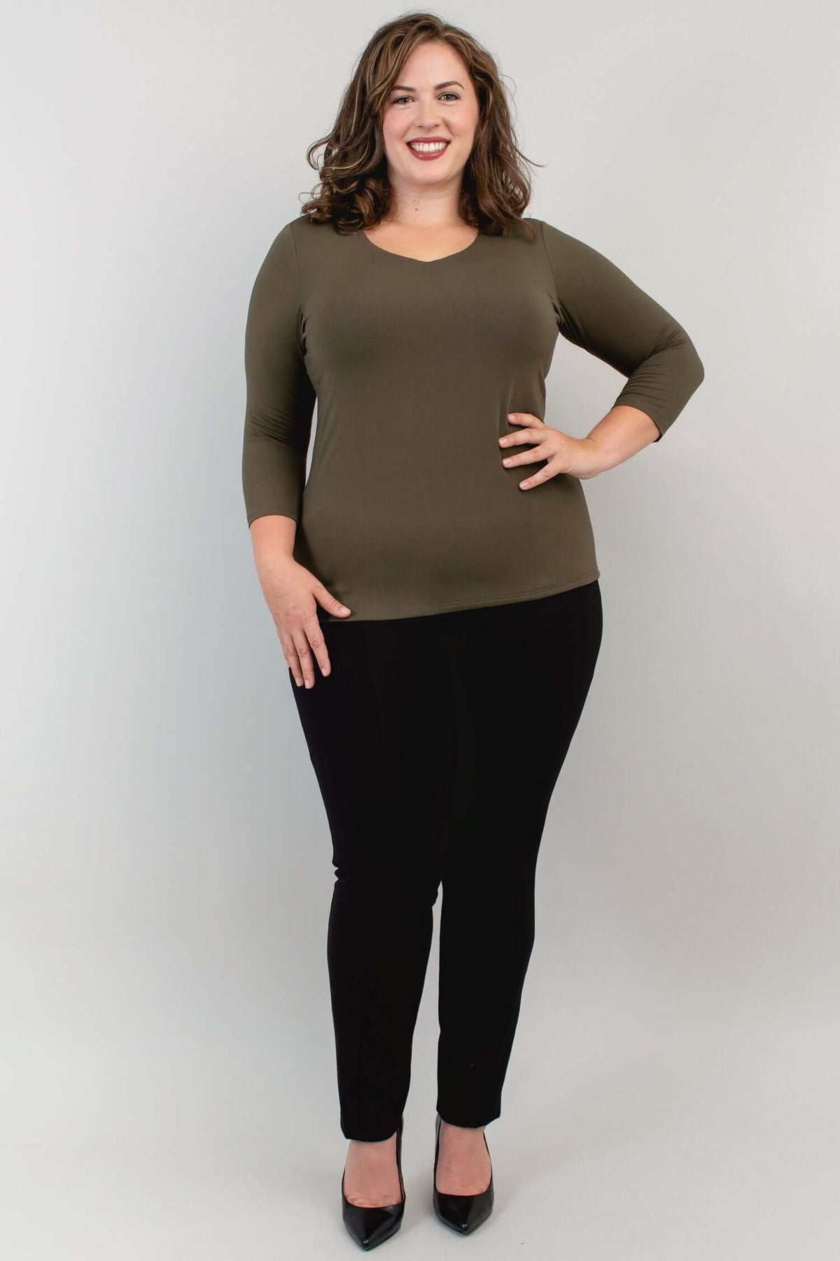 Full-length shot of model in olive bamboo top and black pants