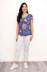 Woman in full-length shot modeling a purple mandala bamboo top with white pants and white sneakers