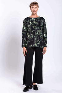 Full-length view of woman in long-sleeve forest print top and black wide-leg pants