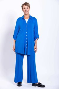 Full-length view of a woman in a blue button-up blouse-jacket and matching wide-leg pants