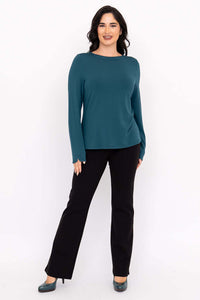 Full body view of woman in teal boat neck top and black pants