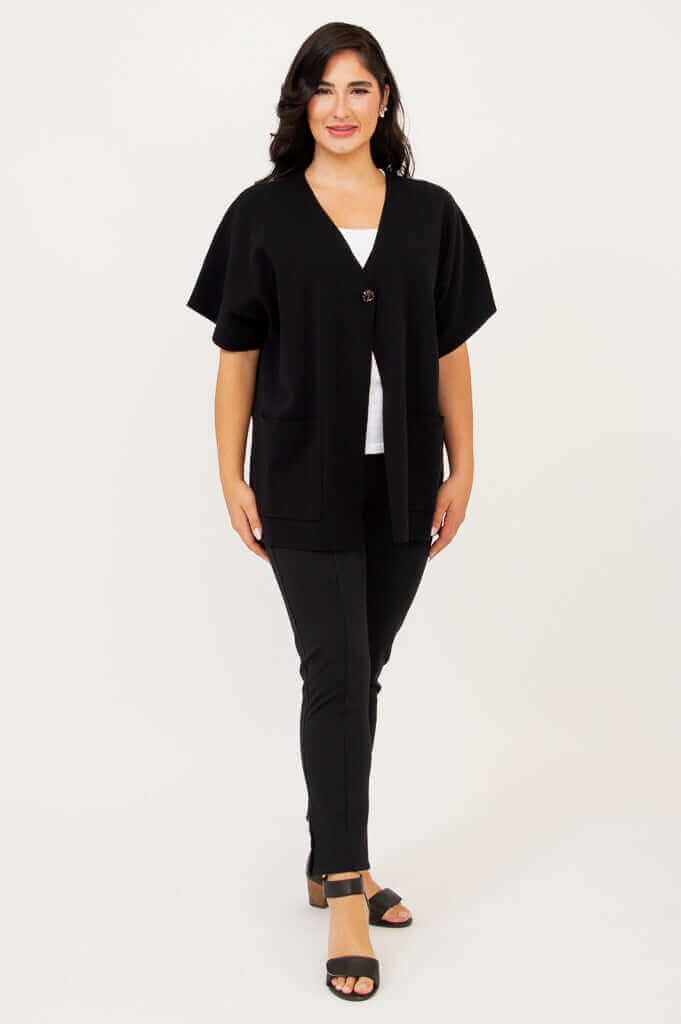 Full body front view of woman in a black cotton cardigan with cropped sleeves and relaxed fit