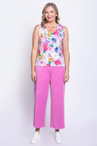 Full body view of woman modeling a sleeveless floral cotton tank and pink pants