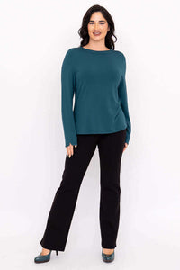 Full body front view of woman modeling teal Mona boat neck top with black pants