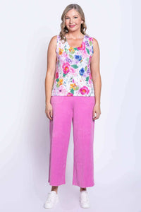 Full body view of woman in floral tank top and pink wide-leg pants, facing forward
