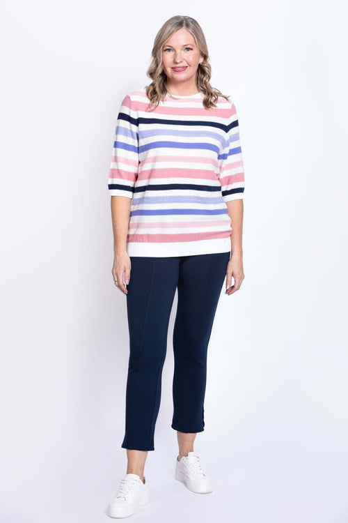 Full body front view of a woman in a striped cotton sweater and navy pants