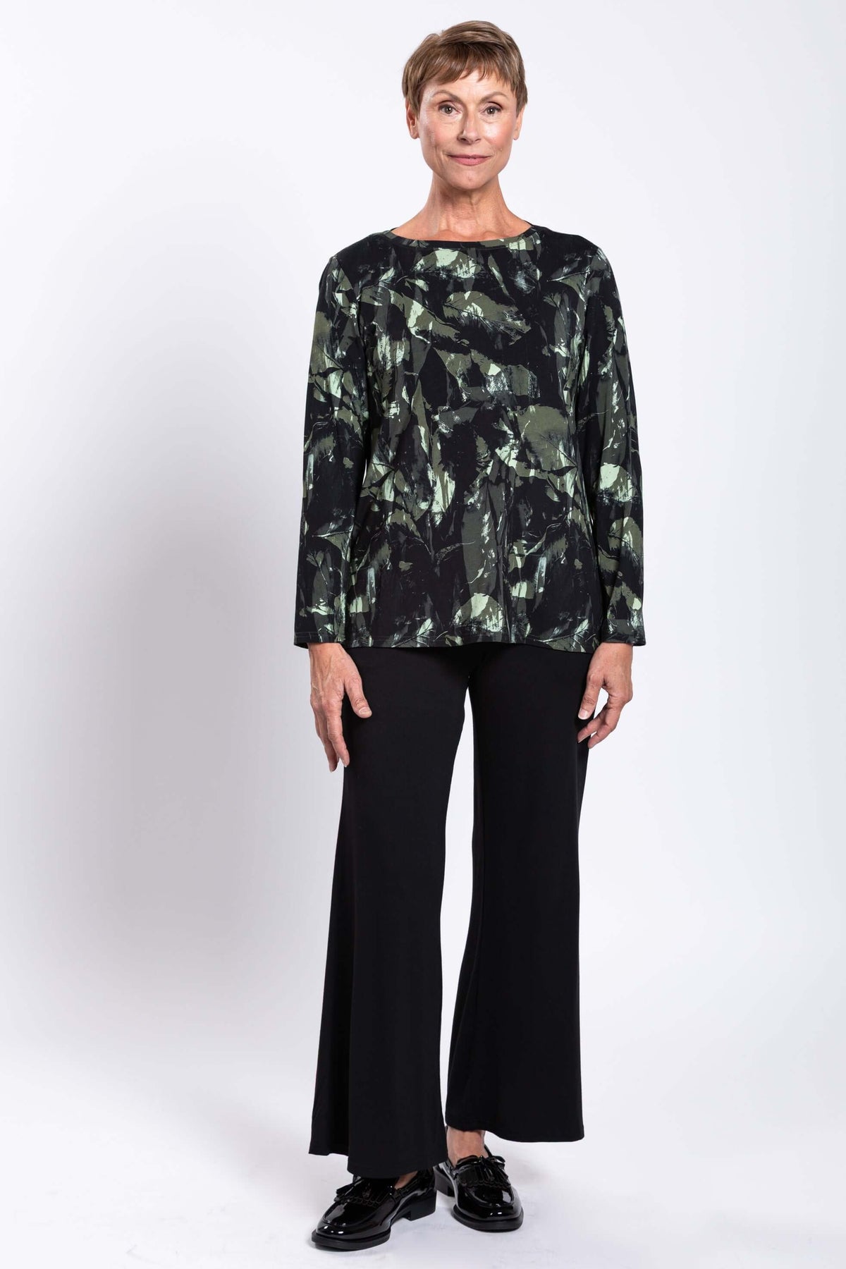Full body front view of a woman modeling a relaxed bamboo print top with black pants