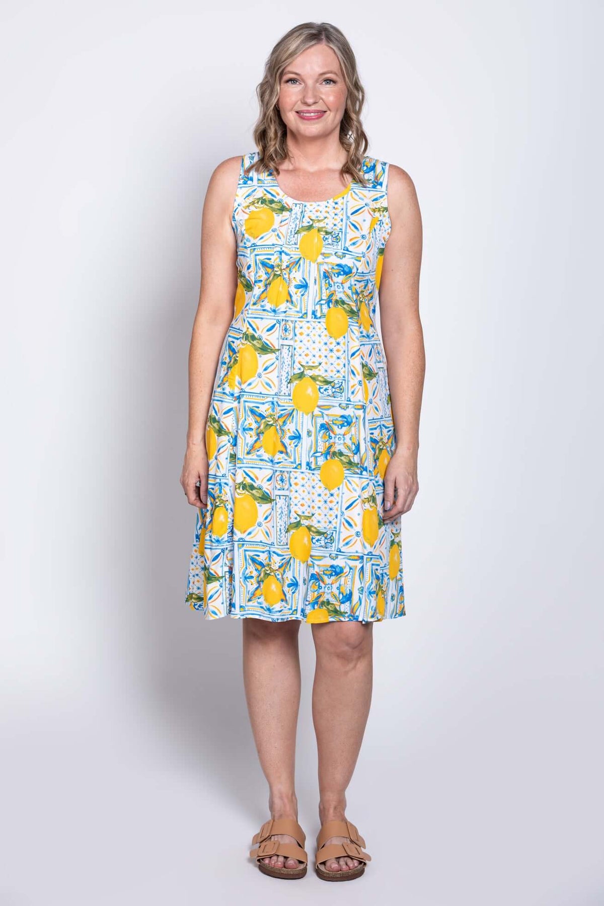 Full body front view of woman modeling bright lemon tile patterned dress