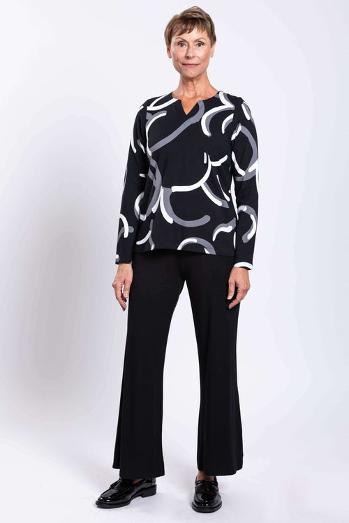 Full body front view of model in black swirl print top and black pants