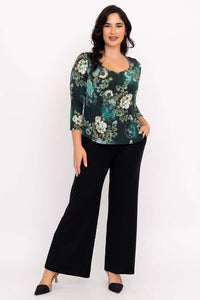 Woman modeling green floral sweetheart top with black wide-leg pants, full body front view