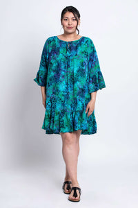 Full body front view of model in Wanda teal and purple patterned dress with flared sleeves