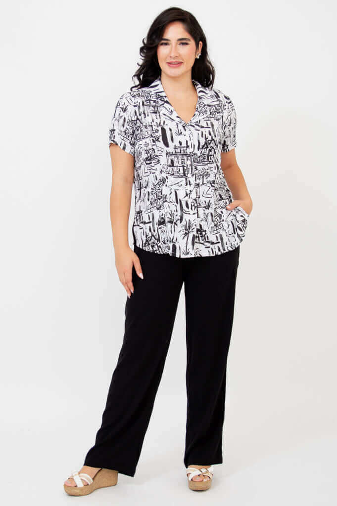 Full body front view of woman in black and white shirt with black pants