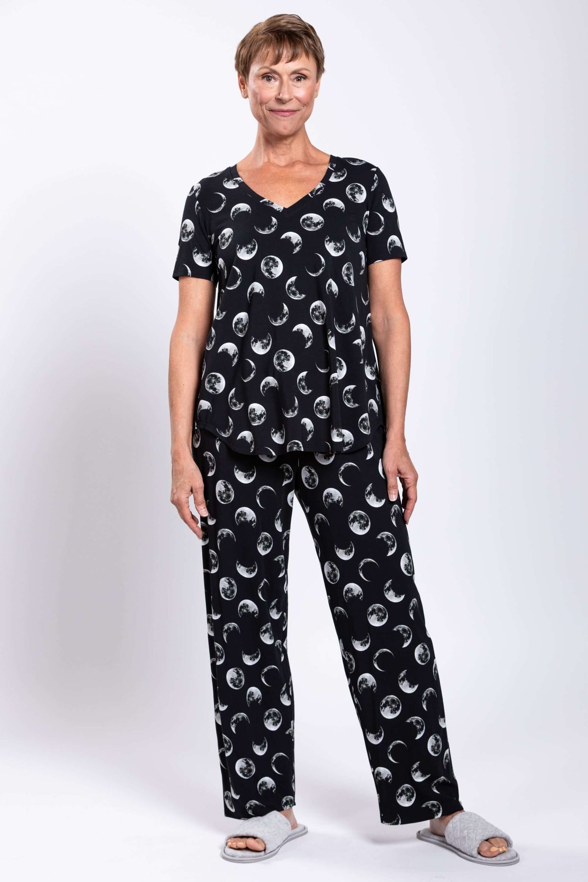 Full body view of woman in matching black moon phase V-neck top and pants, front view