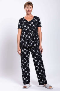 Full body view of woman in matching black moon phase V-neck top and pants, front view