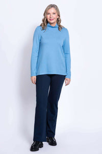 Full body front view of woman in light blue sweater and navy pants