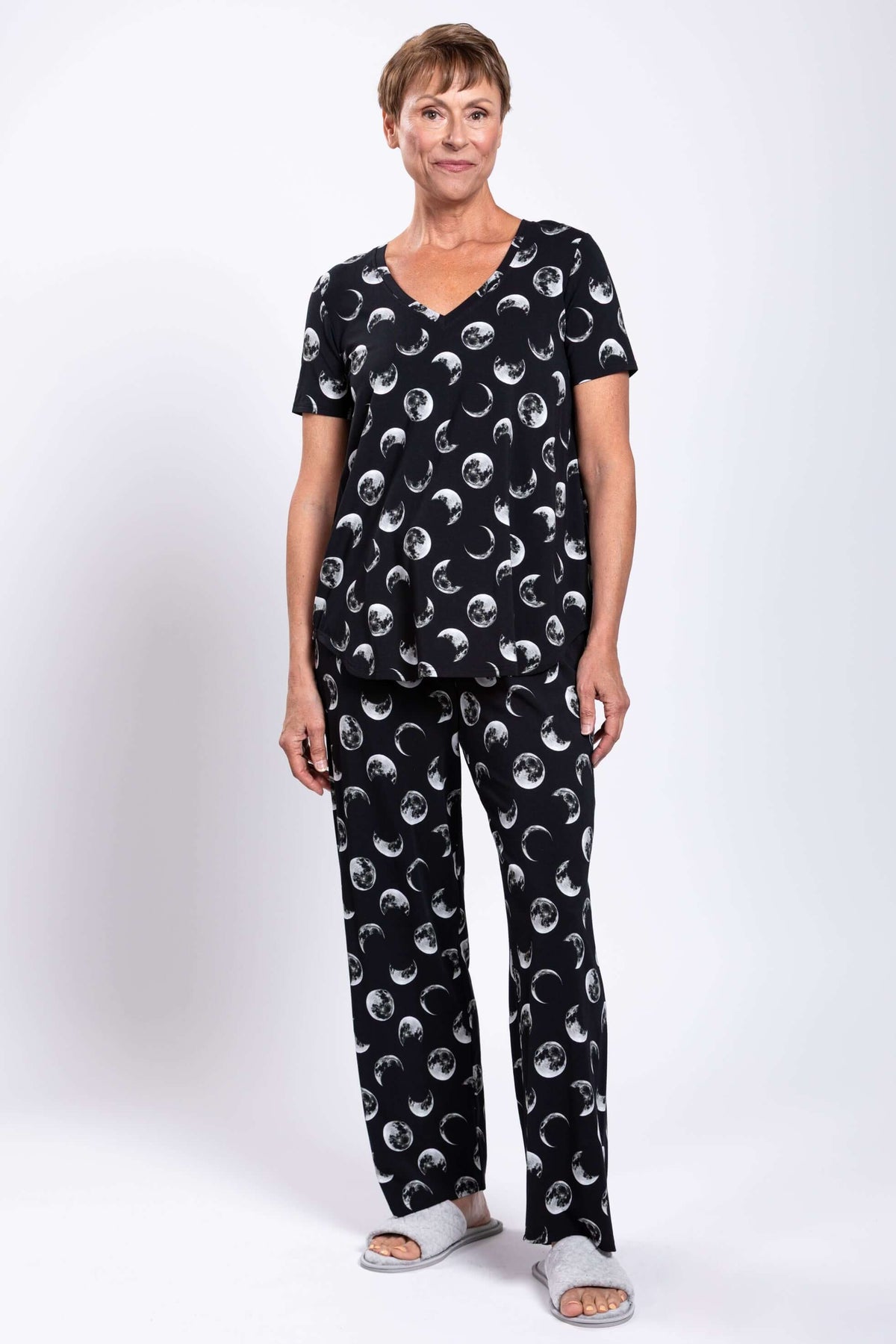 Full body view of woman in black moon phase top and pants, standing, front view