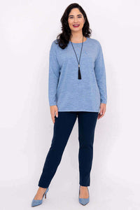 Full body front view of woman wearing light blue sweater and navy pants