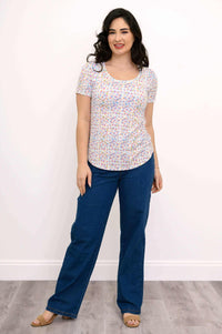 Full front view of woman in pastel confetti scoop neck tee and blue jeans